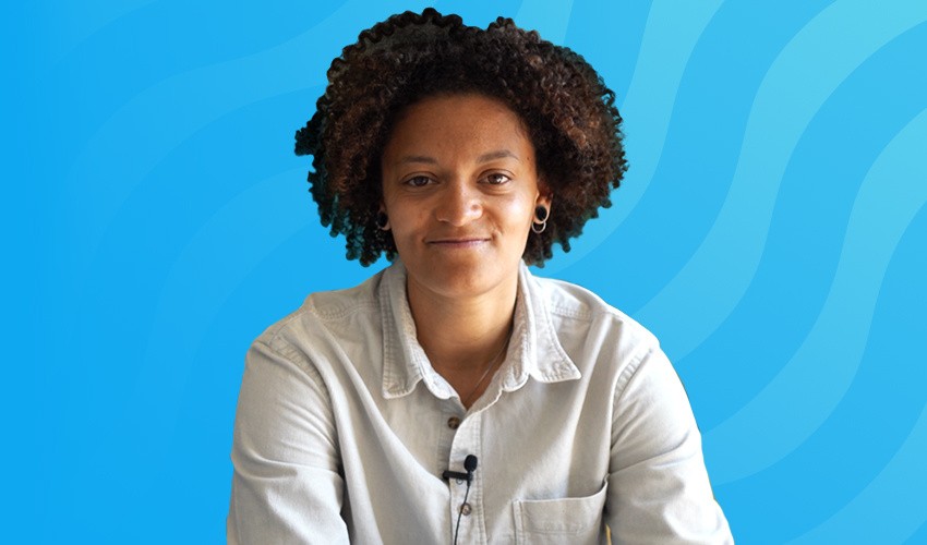 Dr Naomi Gabriel,  Digital Health Partnerships and Patient Impact Coordinator at Evaro, sitting casually on a sofa.