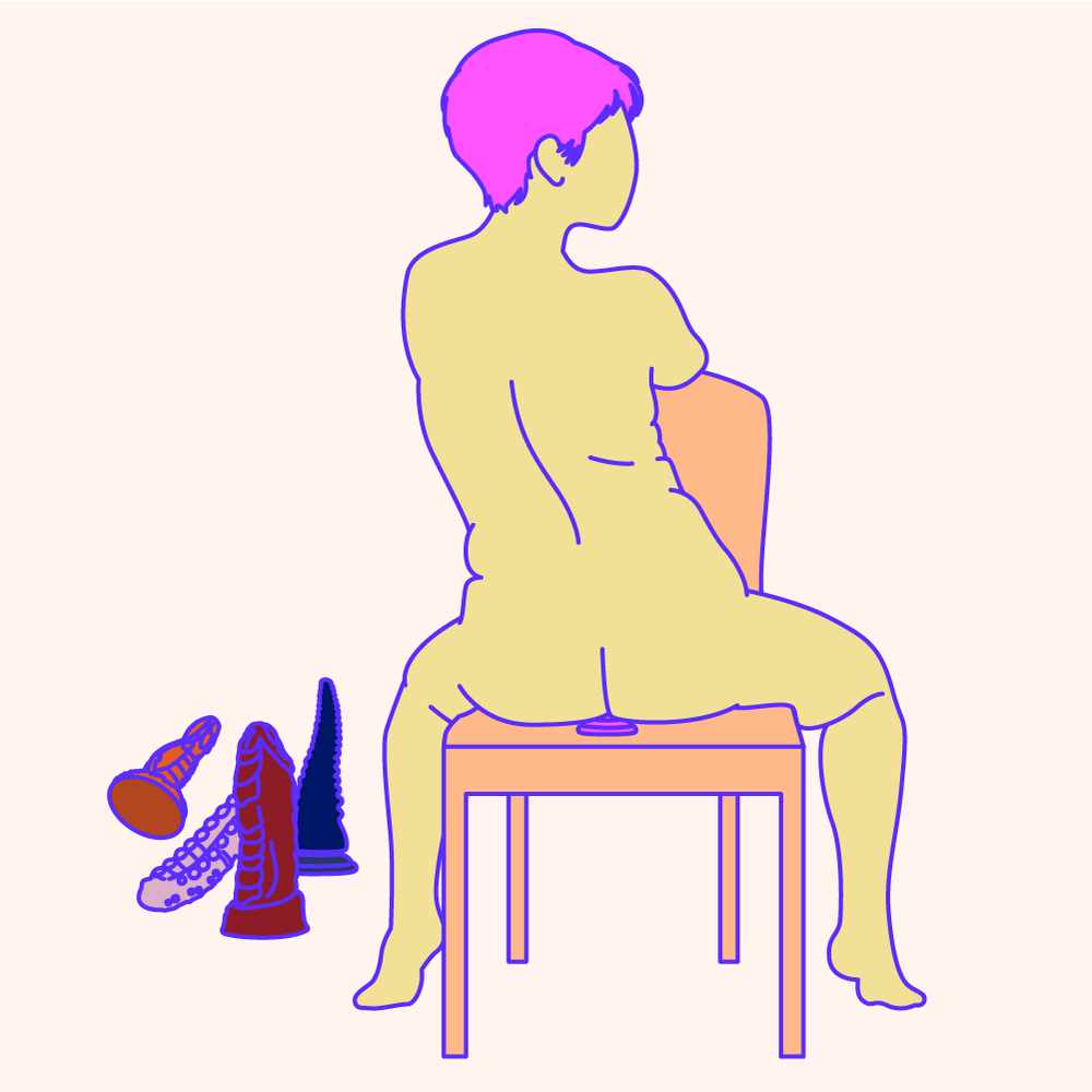 A naked illustrated woman sat on a chair and and facing it. She's also sat on a suction-cup dildo with a collection of dildos beside the chair.