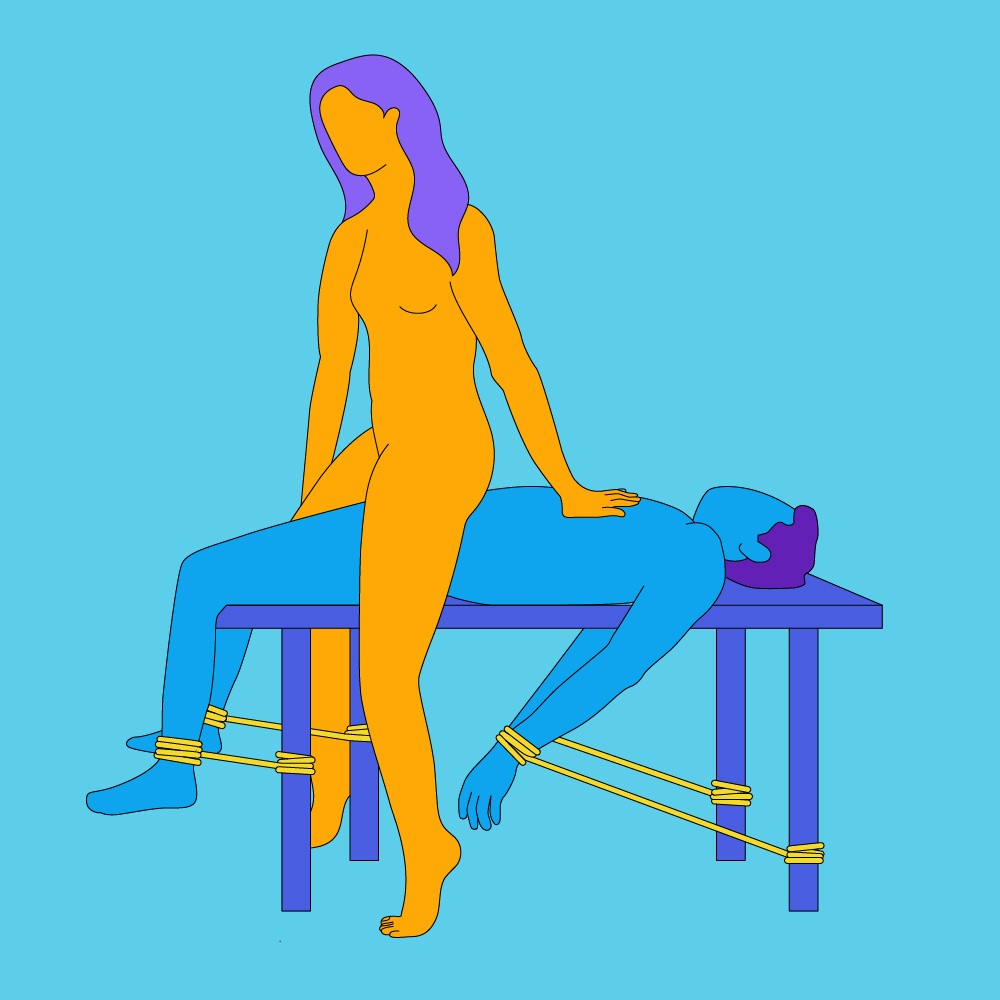 A naked illustrated couple. One is led on a table with their wrists and ankles cuffed to the table legs and the other is sat on them.