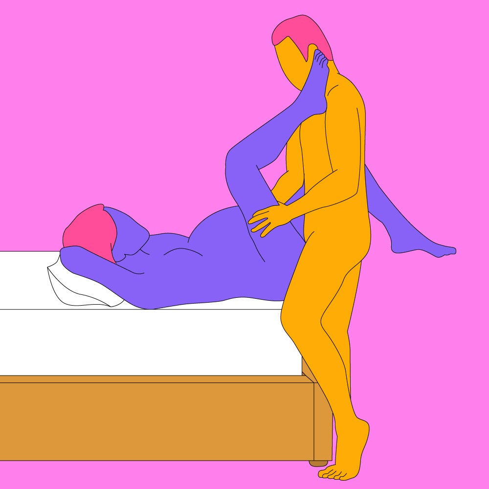 A naked illustrated couple in a penetration position. One is led on a bed and the other is stood against the bed looking at them.