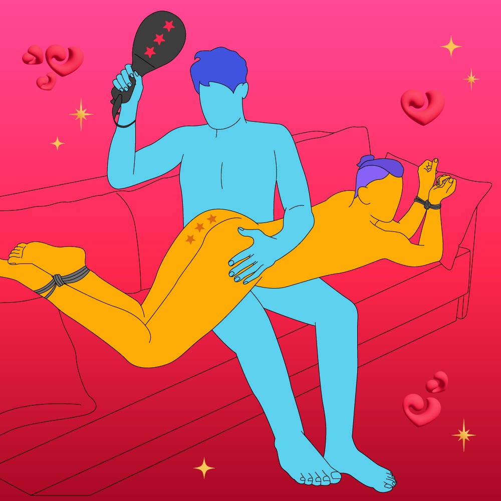 A naked illustrated couple, one is led on their stomach with wrists and ankles tied up, while their partner is sat up and spanking them with a paddle.