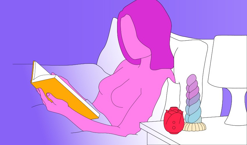 A naked illustrated woman sat in bed reading a book, with a Lovehoney Rose and a Creature Cocks unicorn dildo sat on her bedside table.
