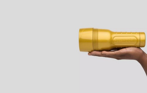 A gold Fleshlight case in a person's hand.